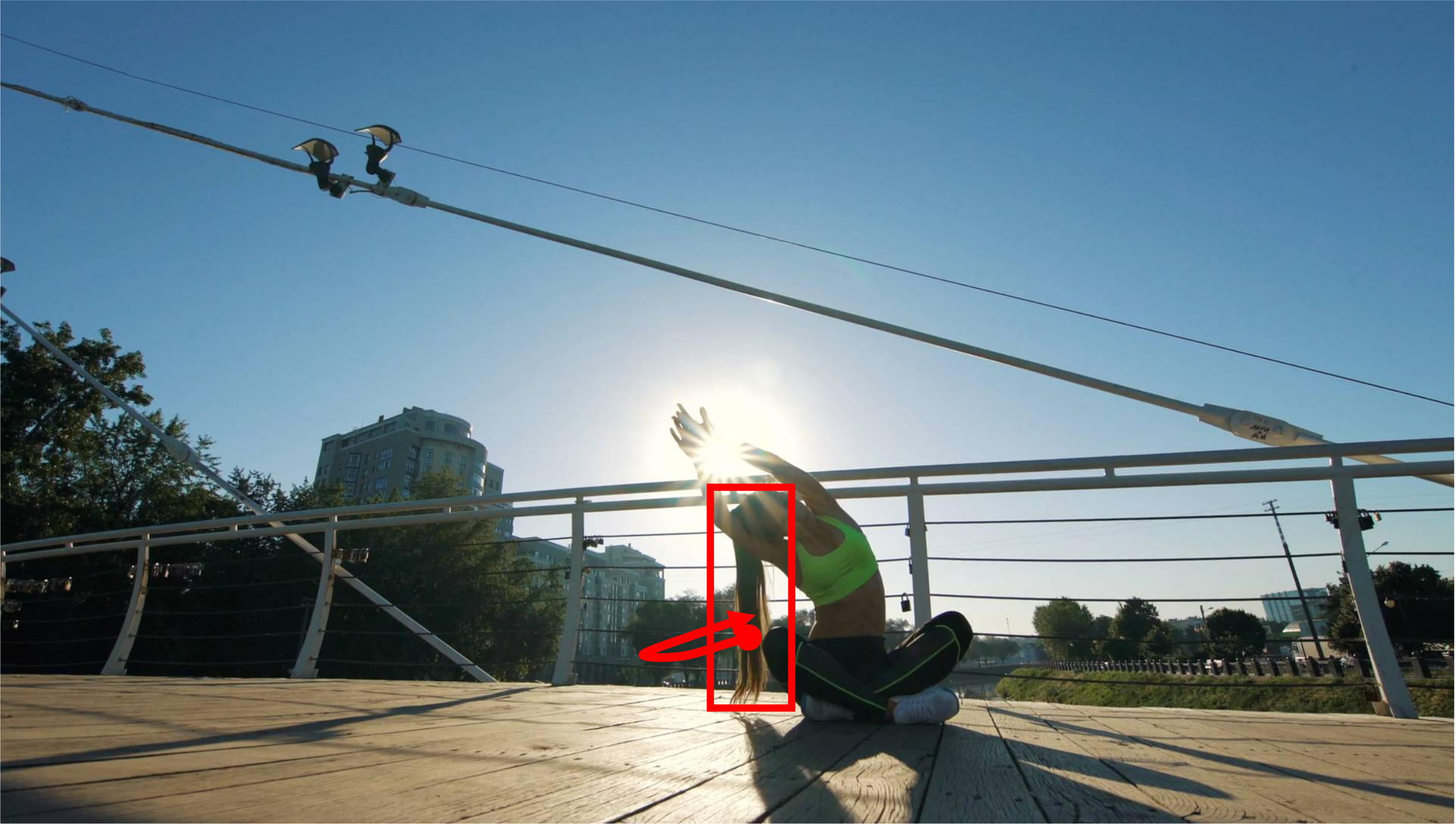 A girl is doing yoga on a rooftop. She is sitting still in one place and does not move her body. Her hair is slowly oscillating. Camera remains stationary. Static Camera. Camera locked down at the same place. The video loops back to the beginning of the video after it reaches the end.